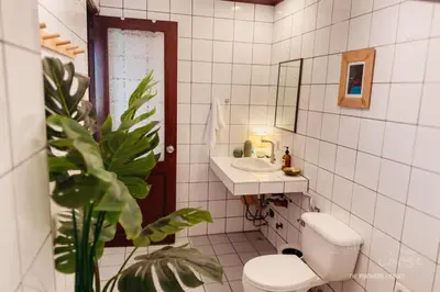 a bathroom with a toilet and a sink and a mirror at Hidden Gem - Spacious Penthouse with Siargao Vibe in Manila
