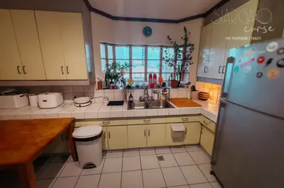 a kitchen with a sink and a refrigerator at Hidden Gem - Spacious Penthouse with Siargao Vibe in Manila