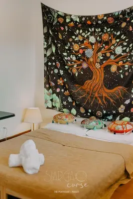 a bed with a tree blanket on top of it at Hidden Gem - Spacious Penthouse with Siargao Vibe in Manila