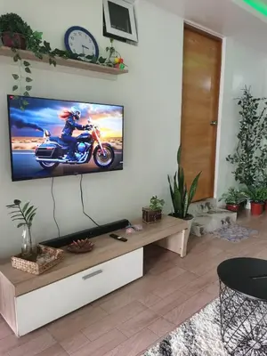 a living room with a flat screen tv on a wall at Cozy Private Retreat with Kitchen & Balcony in Bacoor