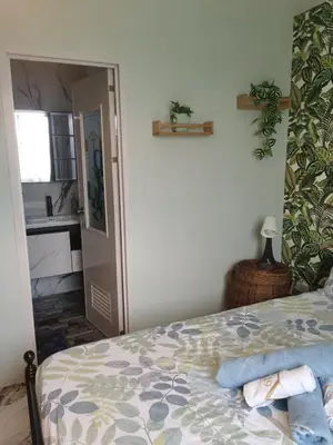 a bedroom with a bed and a bathroom with a sink at Cozy Private Retreat with Kitchen & Balcony in Bacoor