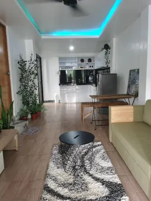 a living room with a couch and a table at Cozy Private Retreat with Kitchen & Balcony in Bacoor