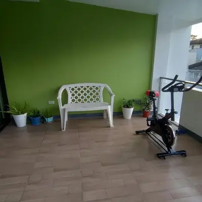 a room with a white bench and a exercise bike at Cozy Private Retreat with Kitchen & Balcony in Bacoor