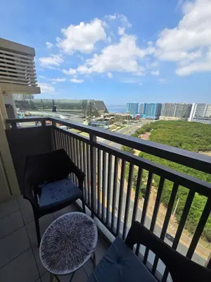 a balcony with a chair and a view of the ocean at Gentry Manor Okada Westside City Paranaque by Royale Prestige Le Maison in Manila
