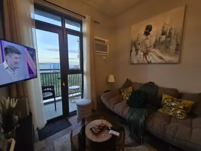 a living room with a couch and a flat screen tv at Gentry Manor Okada Westside City Paranaque by Royale Prestige Le Maison in Manila