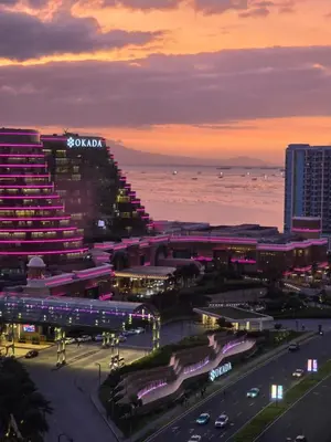 a view of a city at night with the ocean at Gentry Manor Okada Westside City Paranaque by Royale Prestige Le Maison in Manila