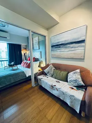 a living room with a couch and a bedroom at Pahinga Luxury Stays in Manila