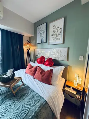 a bedroom with a bed with red pillows on it at Pahinga Luxury Stays in Manila