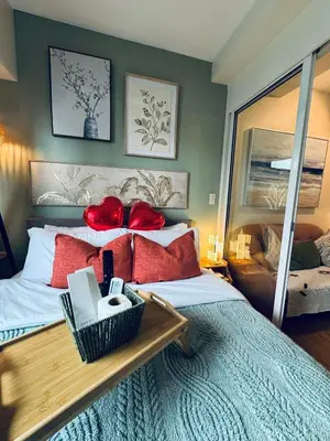 a bedroom with a large bed with red pillows at Pahinga Luxury Stays in Manila