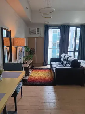 a living room with a black couch and a table at Cluster 1 9N in Manila