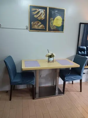 a desk with two chairs and a table with flowers on it at Cluster 1 9N in Manila