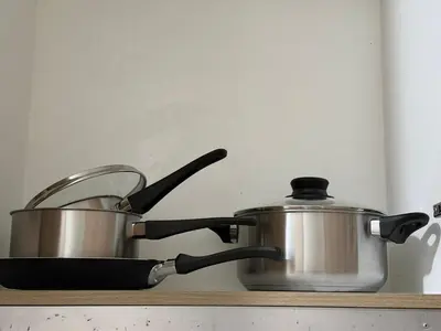 a pan and a pot sitting on a stove at Nordic Style 1br Shore 2 Residences Tower 3 in Manila