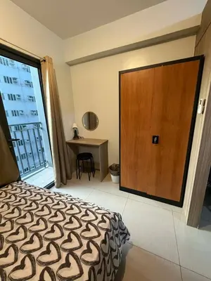a bedroom with a bed and a large wooden door at Nordic Style 1br Shore 2 Residences Tower 3 in Manila