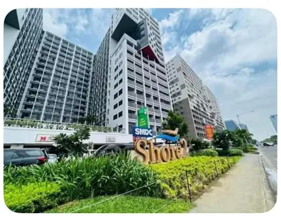 a sign for a store in front of tall buildings at Nordic Style 1br Shore 2 Residences Tower 3 in Manila