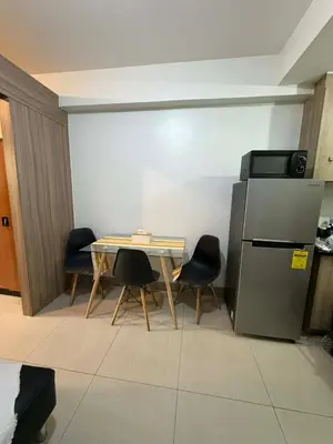 a small kitchen with a table and a refrigerator at Nordic Style 1br Shore 2 Residences Tower 3 in Manila
