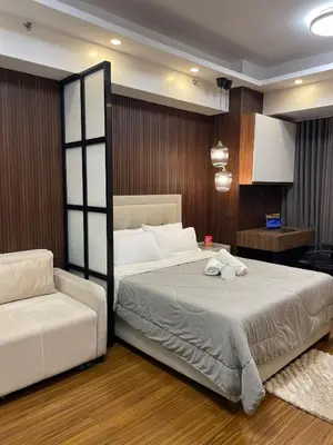 a bedroom with a large bed and a chair at 81 Newport Building across NAIA Terminal 3 C5-8C in Manila