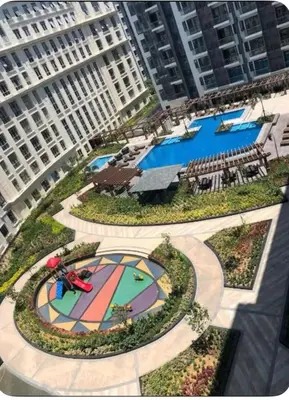 an overhead view of a pool in a city with buildings at 81 Newport Building across NAIA Terminal 3 C5-8C in Manila