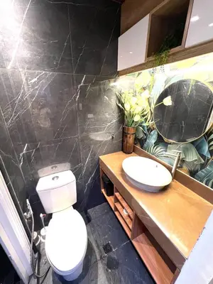a bathroom with a toilet and a sink and a mirror at Shore Residences Direct Pool Access in Manila