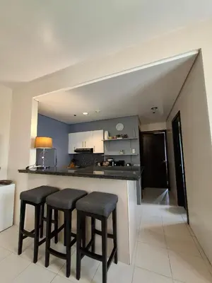 a kitchen with three bar stools and a counter at Cozy Hotel-Style 2 Bedroom Condo Unit at Eastbay Residences by Rockwell in Manila