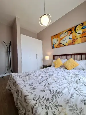 a bedroom with a large white bed with yellow pillows at Cozy Hotel-Style 2 Bedroom Condo Unit at Eastbay Residences by Rockwell in Manila