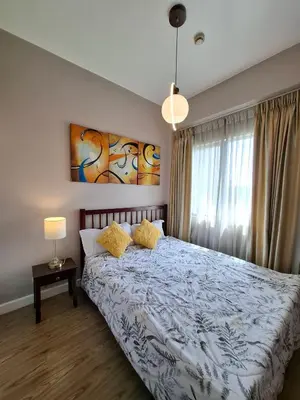 a bedroom with a bed with yellow pillows at Cozy Hotel-Style 2 Bedroom Condo Unit at Eastbay Residences by Rockwell in Manila