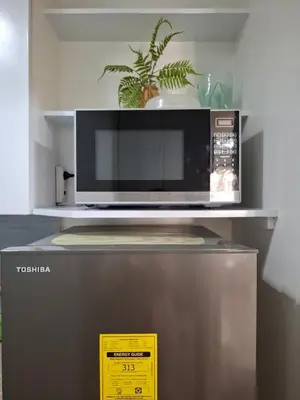 a microwave oven sitting on top of a refrigerator at Cozy Hotel-Style 1 Bedroom Condo Unit Bryant Tower 12E at Eastbay Residences by Rockwell in Manila
