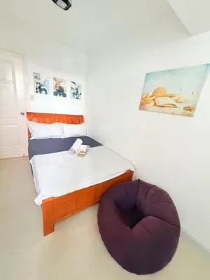 a small bedroom with a bed with a purple ottoman at Azure Destiny's Suites 1912 in Manila