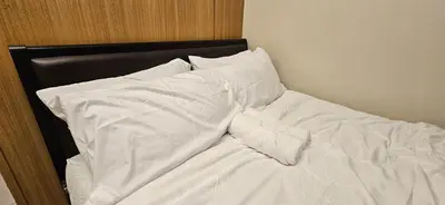 an unmade bed with white sheets and pillows at Low Floor 1BR Balcony Shell near MOA Shell001 in Manila