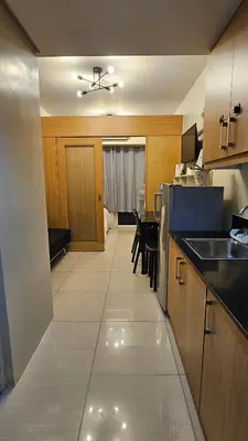 a kitchen with a table and a counter top at Low Floor 1BR Balcony Shell near MOA Shell001 in Manila