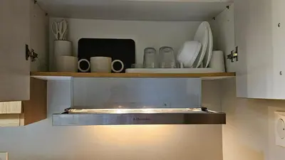 a kitchen with a shelf with plates and utensils at Low Floor 1BR Balcony Shell near MOA Shell001 in Manila