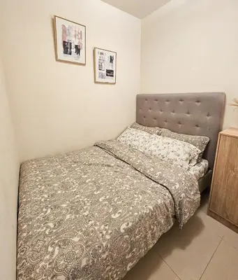 a bedroom with a bed with a gray bedspread at Haven Home in Manila