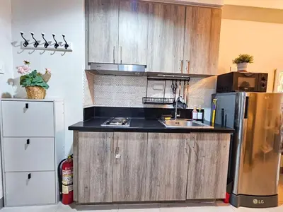 a kitchen with a sink and a refrigerator at Haven Home in Manila