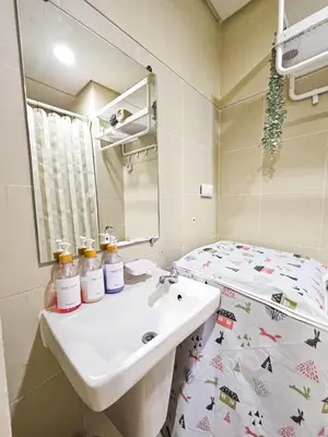 a bathroom with a sink and a mirror and a bed at Haven Home in Manila