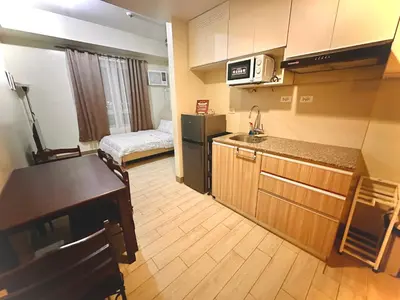 a small kitchen with a sink and a bed in a room at Cozy maple grove studio with hot shower in General Trias