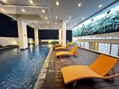 a swimming pool with yellow chairs and a swimming pool at Cozy maple grove studio with hot shower in General Trias