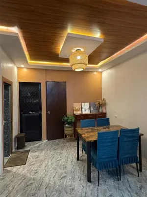 a dining room with a table and blue chairs at Tan's Homestay in Trece Martires