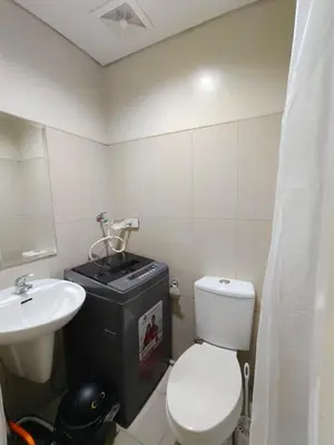 a bathroom with a white toilet and a sink at MOA Condo Stay with balcony Pool View 2 Beds in Manila
