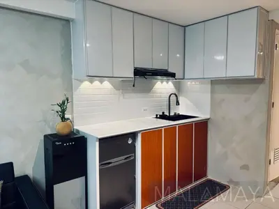 a kitchen with white cabinets and a sink at Malamaya Staycation in Manila