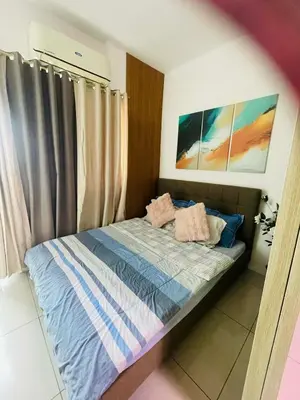 a bed with two pillows on it in a bedroom at Breeze Residences in Manila