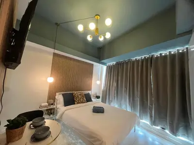a bedroom with a white bed and a window at Bleau Haven KL Service Residences Makati in Manila