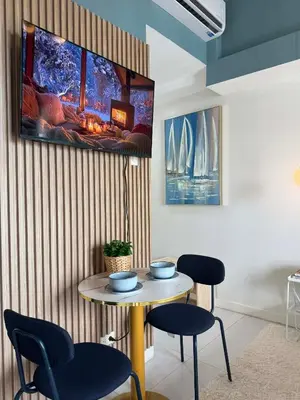 a room with a table and chairs and a tv on the wall at Bleau Haven KL Service Residences Makati in Manila