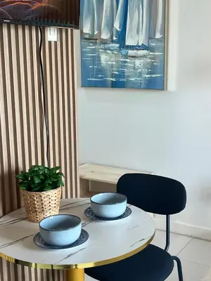 a table with bowls on top of it with a chair at Bleau Haven KL Service Residences Makati in Manila