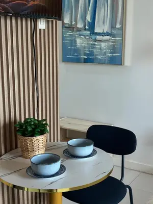 a table with bowls on top of it with a chair at Bleau Haven KL Service Residences Makati in Manila