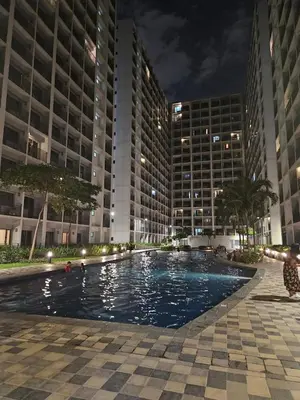 a swimming pool in front of a building at night at Shore 2 Tower 2 Pool View 1BR near MOA and NAIA Shore003 in Manila