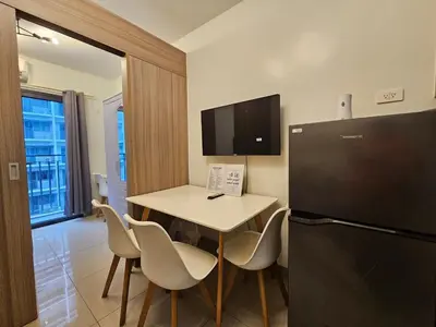a small kitchen with a table and a refrigerator at Shore 2 Tower 2 Pool View 1BR near MOA and NAIA Shore003 in Manila