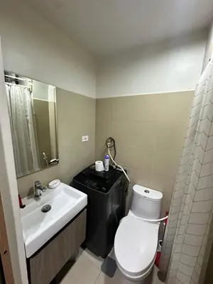 a bathroom with a white toilet and a sink at Gateway mall of asia shore 3 near Airport Malls in Manila