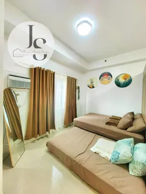 a bedroom with two beds and a chandelier at Staycation near MOA in Manila