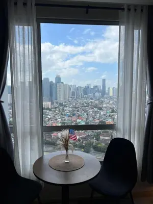 a table in front of a window with a view of a city at Great View at Pioneer Mandaluyong Free Pool Gym Netflix Fast Wifi in Manila