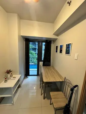 a dining room with a table and a table and chairs at Gateway Mall of Asia Near Airport in Manila