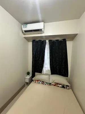 a small bedroom with a bed with a window at Gateway Mall of Asia Near Airport in Manila